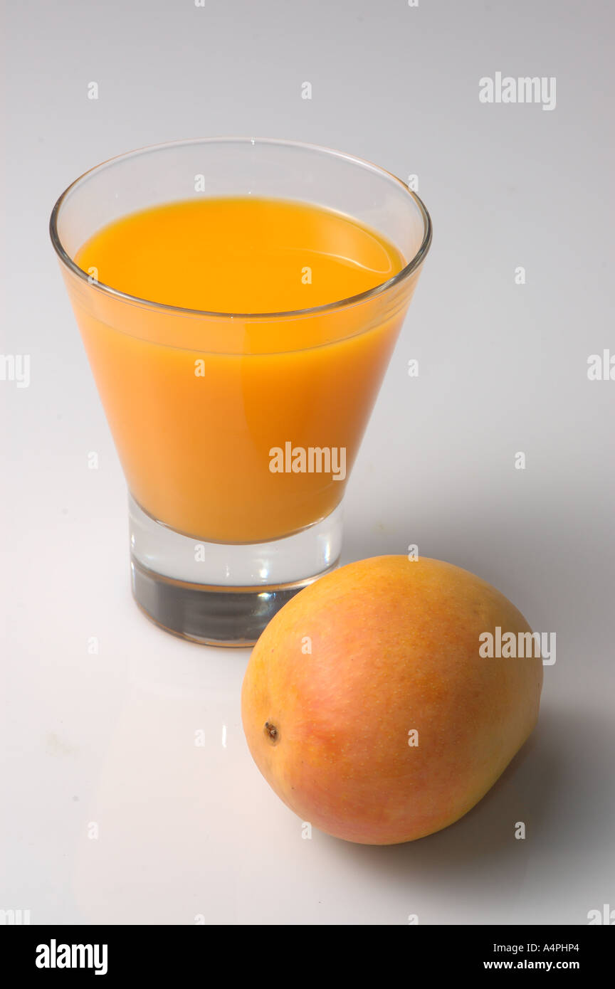 ANG77740 Mango jus de fruit dans le verre, un morceau de mangue mûre uncut plein Banque D'Images