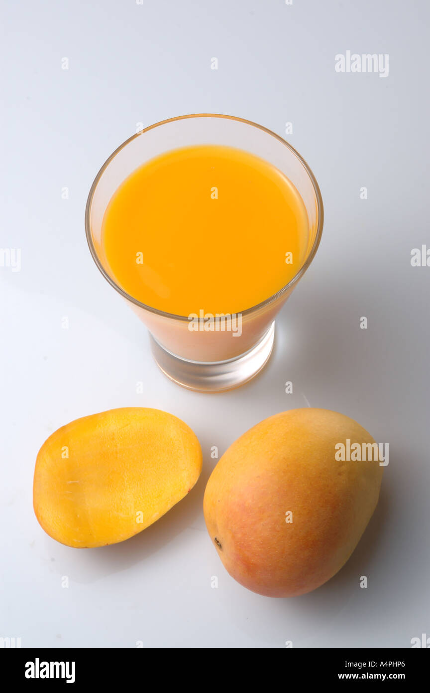 ANG77741 Mango jus de fruit dans le verre, un morceau de coupe et un plein uncut mangue mûre Banque D'Images