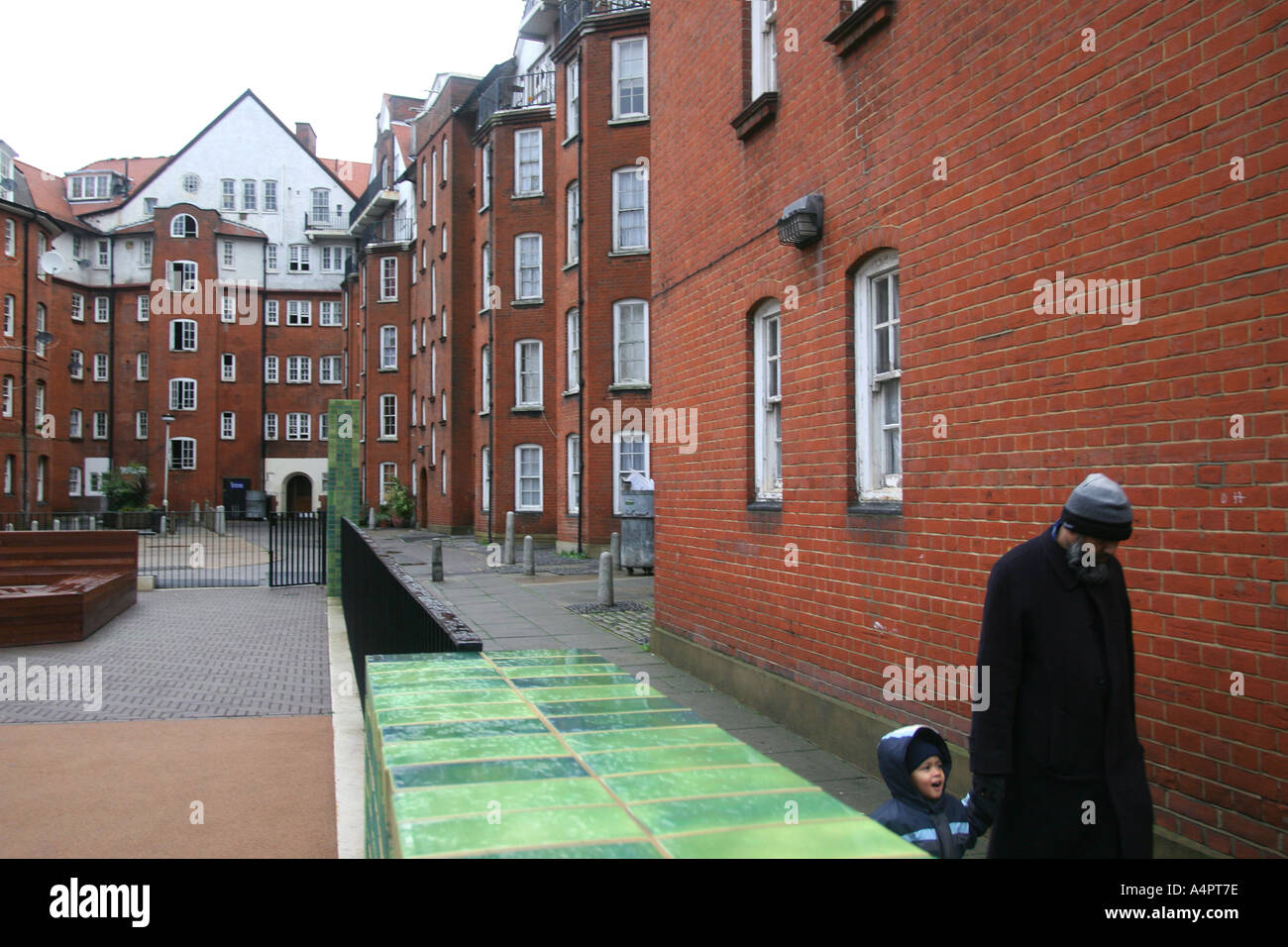 Asian man & boy walking passé régénéré le logement social à Shoreditch, London, UK. Banque D'Images