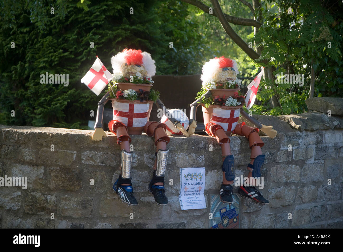 Modèles de Bill et Ben le pot de fleurs hommes habillés et en Angleterre les supporters de football ont siégé en un mur de jardin Wass Angleterre Yorkshire UK Banque D'Images