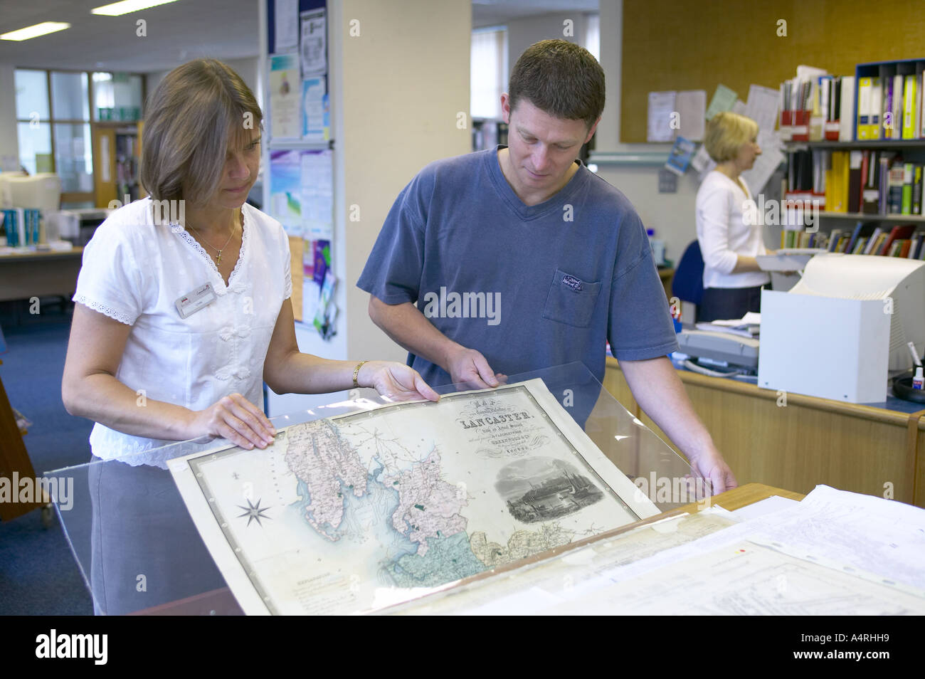 Librarian aider un client à étudier une carte de l'archive de référence Banque D'Images
