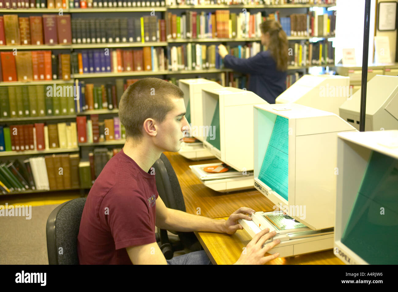 Jeune homme étudiant archives microfilm à l'échelle locale bureau des documents du comté de Lancashire England UK Banque D'Images