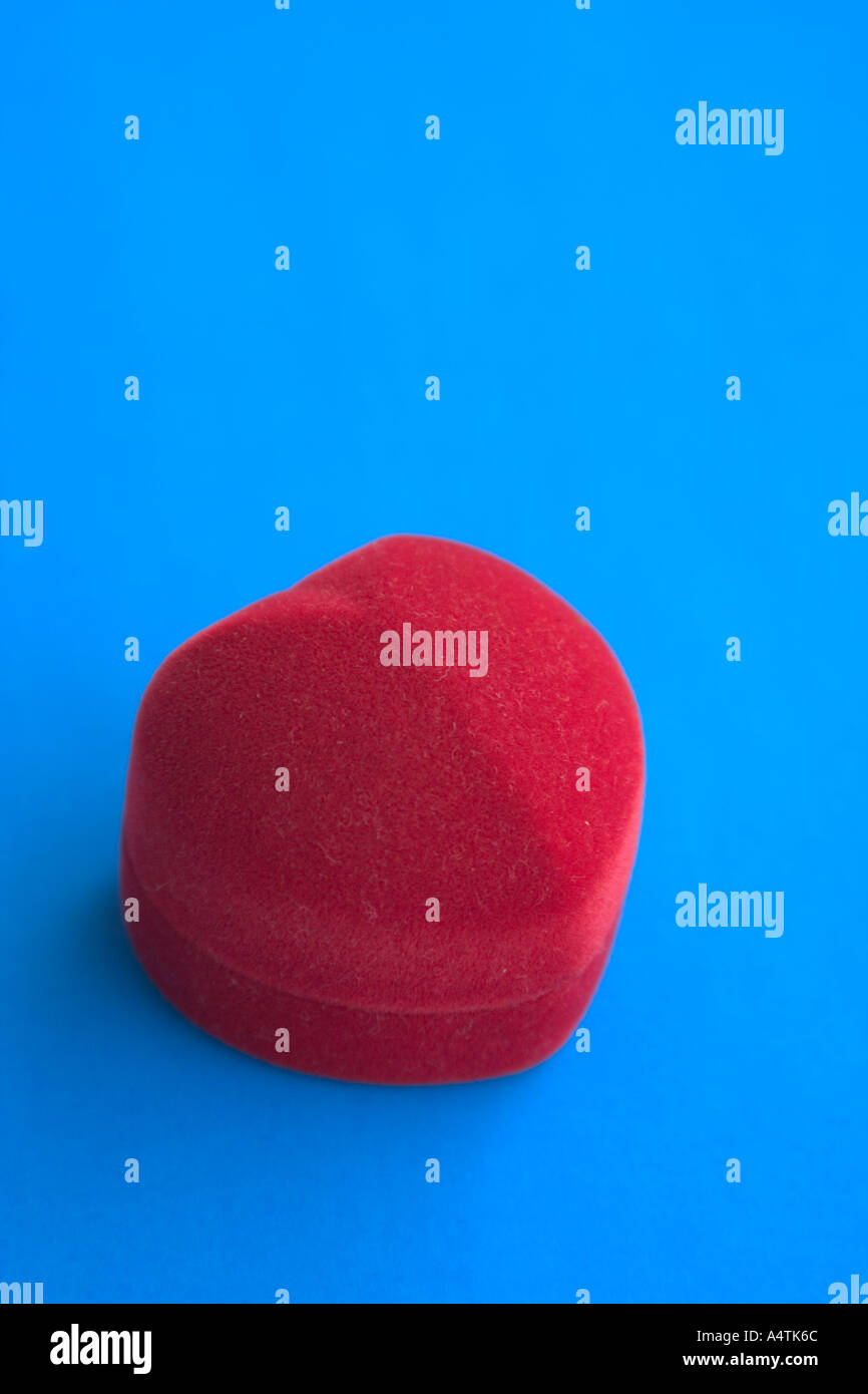 Boîtier en forme de cœur rouge contraste avec le fond bleu Banque D'Images