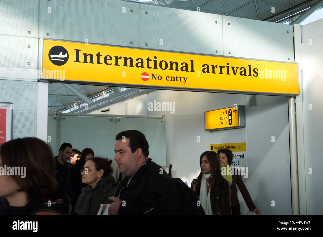 Les passagers passant par l'arrivée des vols internationaux à Stansted, Angleterre, Royaume-Uni Banque D'Images