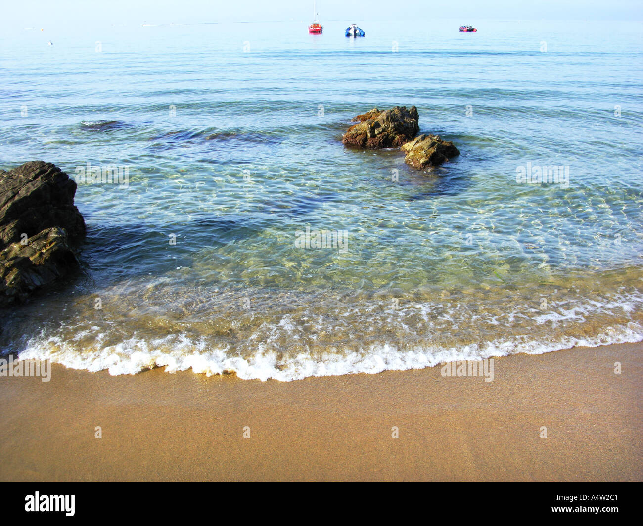 COTE D AZUR plage de sable au bord de l'eau claire de la mer bleu bateau naviguant de tôt le matin à moteur arrière-plan des sentiments de foam Banque D'Images