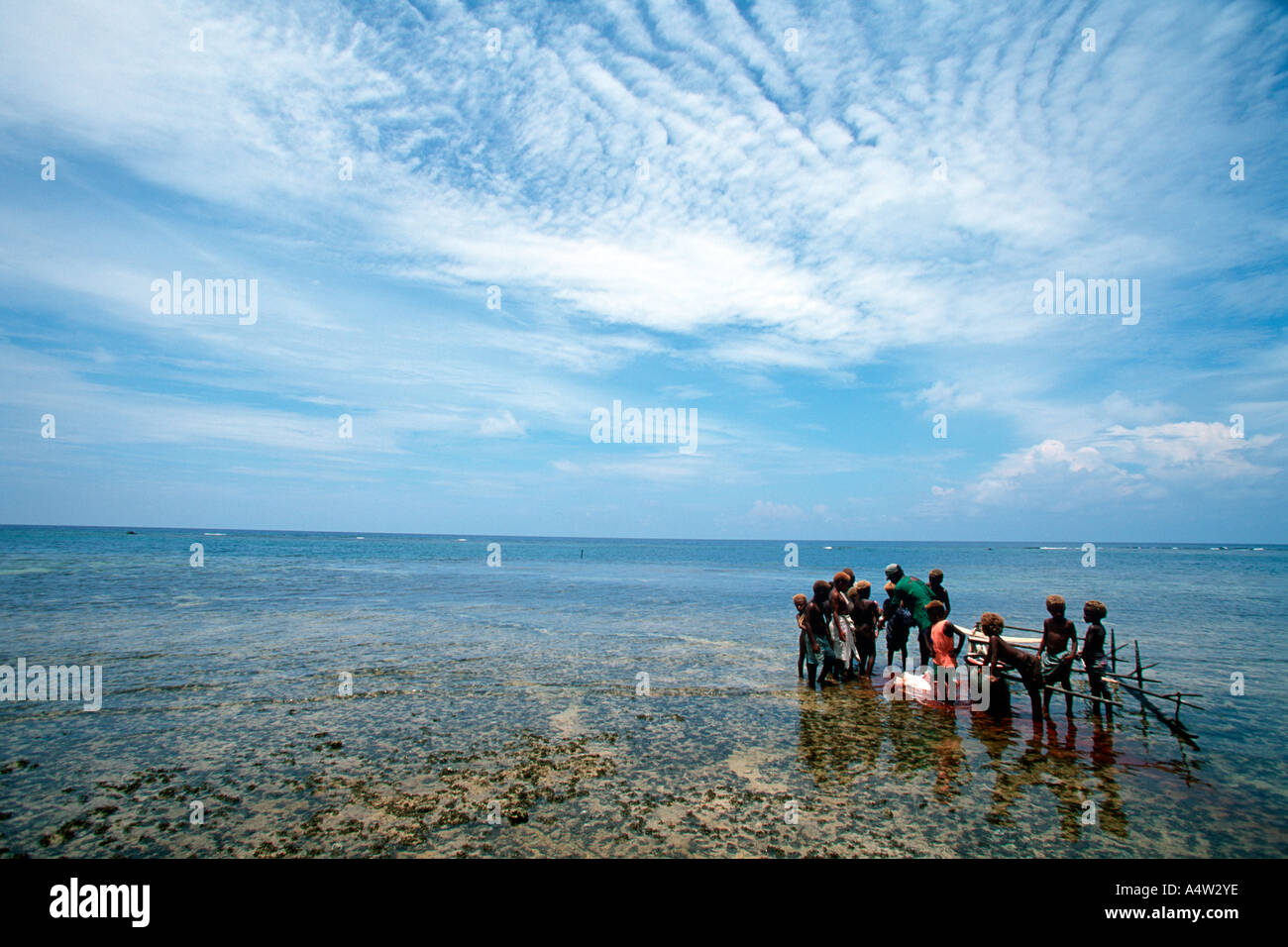 Un requin Obet appelant de Kontu village est entouré d'enfants excités après avoir présenté un requin qu'il a capturé Banque D'Images
