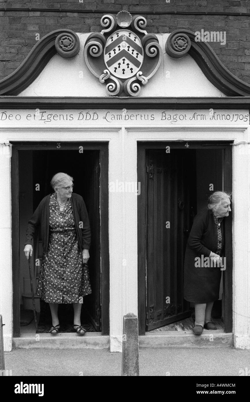 Almshouse deux résidantes âgées se tiennent dans les portes sous les armoiries de la famille Baggot. Abbés Bromley Staffordshire 1973 1970s Royaume-Uni Banque D'Images