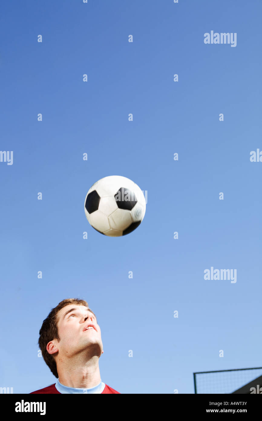 L'homme à la tête d'un ballon de soccer Banque D'Images