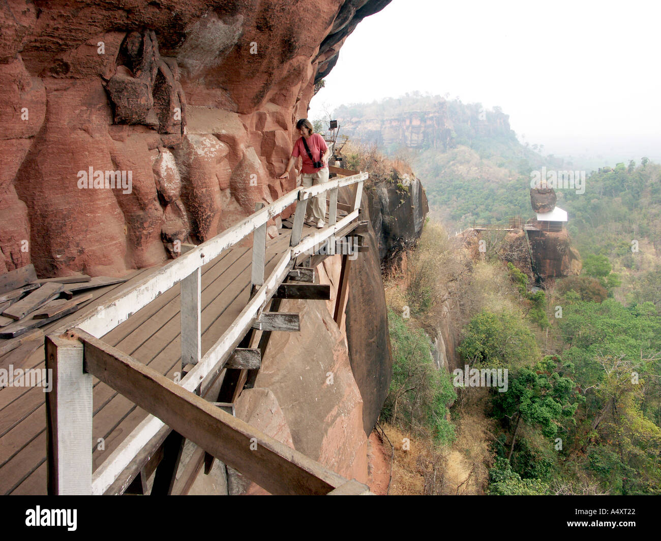 Un touriste négocie la passerelle branlante au-dessus de la plaine du nord est de la Thaïlande autour de Wat Phu Tok Banque D'Images