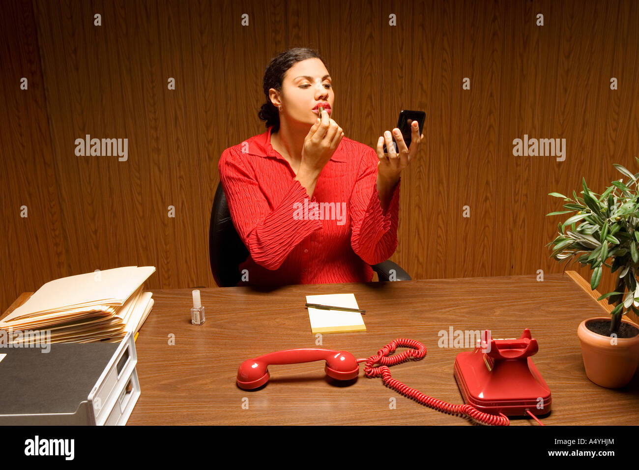 Woman applying lipstick avec téléphone off the hook Banque D'Images Woman applying lipstick avec téléphone off the hook Banque D'Images