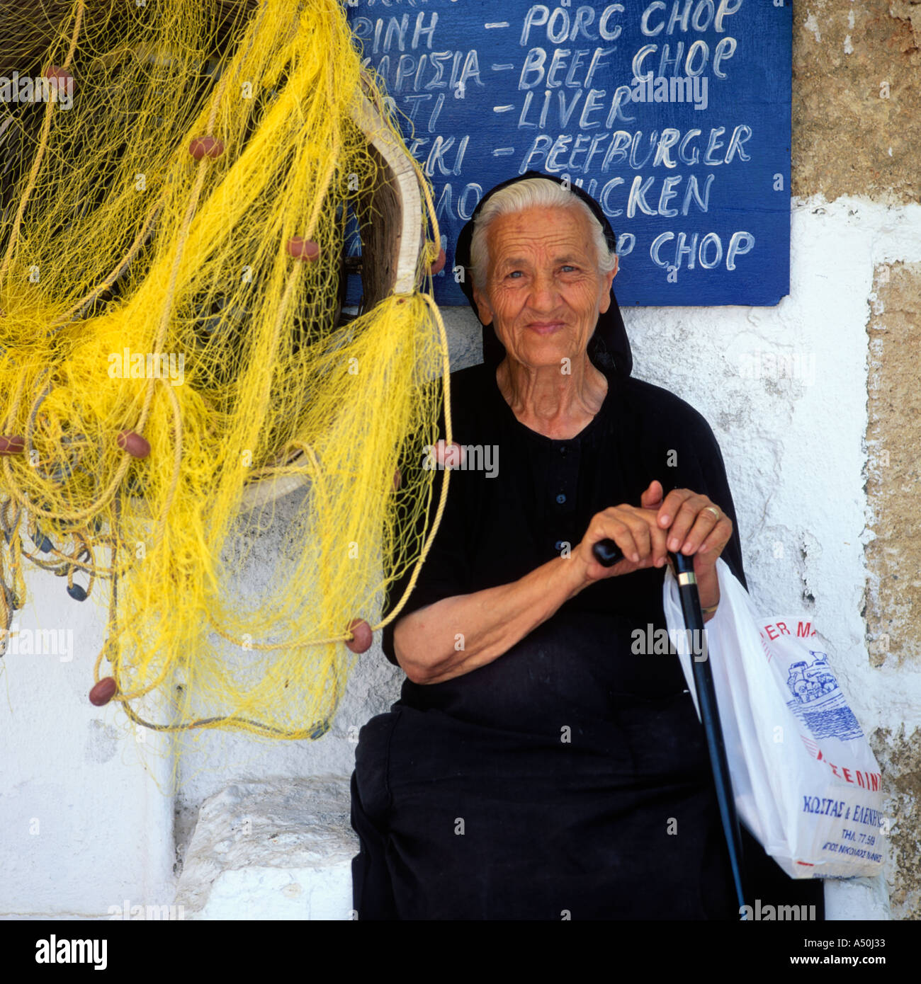PORTRAIT D'une vieille femme grecque assis à côté des filets de pêche Banque D'Images