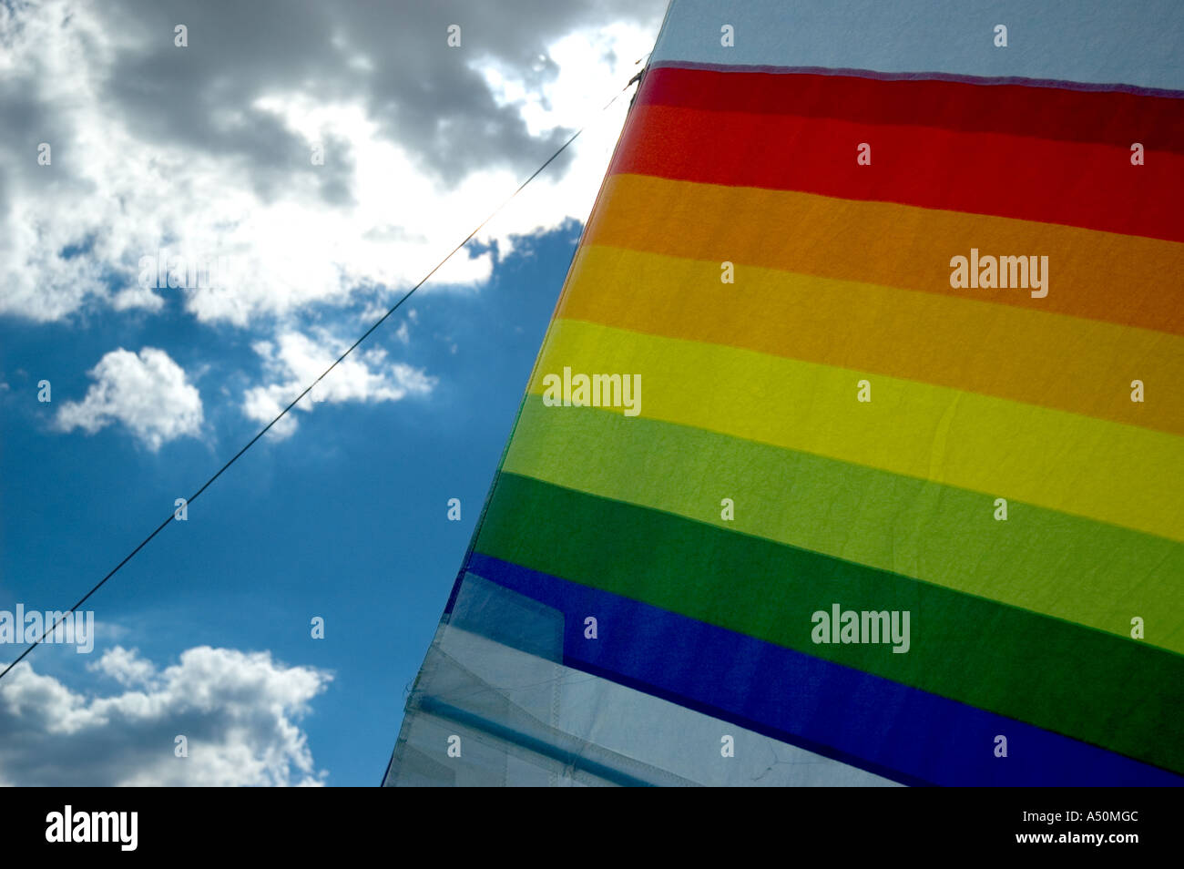 Voile arc-en-ciel sur un voilier placé contre un ciel bleu brillant et des  nuages - haute en couleur sur un canot LGBTQ / LGBT gay Pride Photo Stock -  Alamy