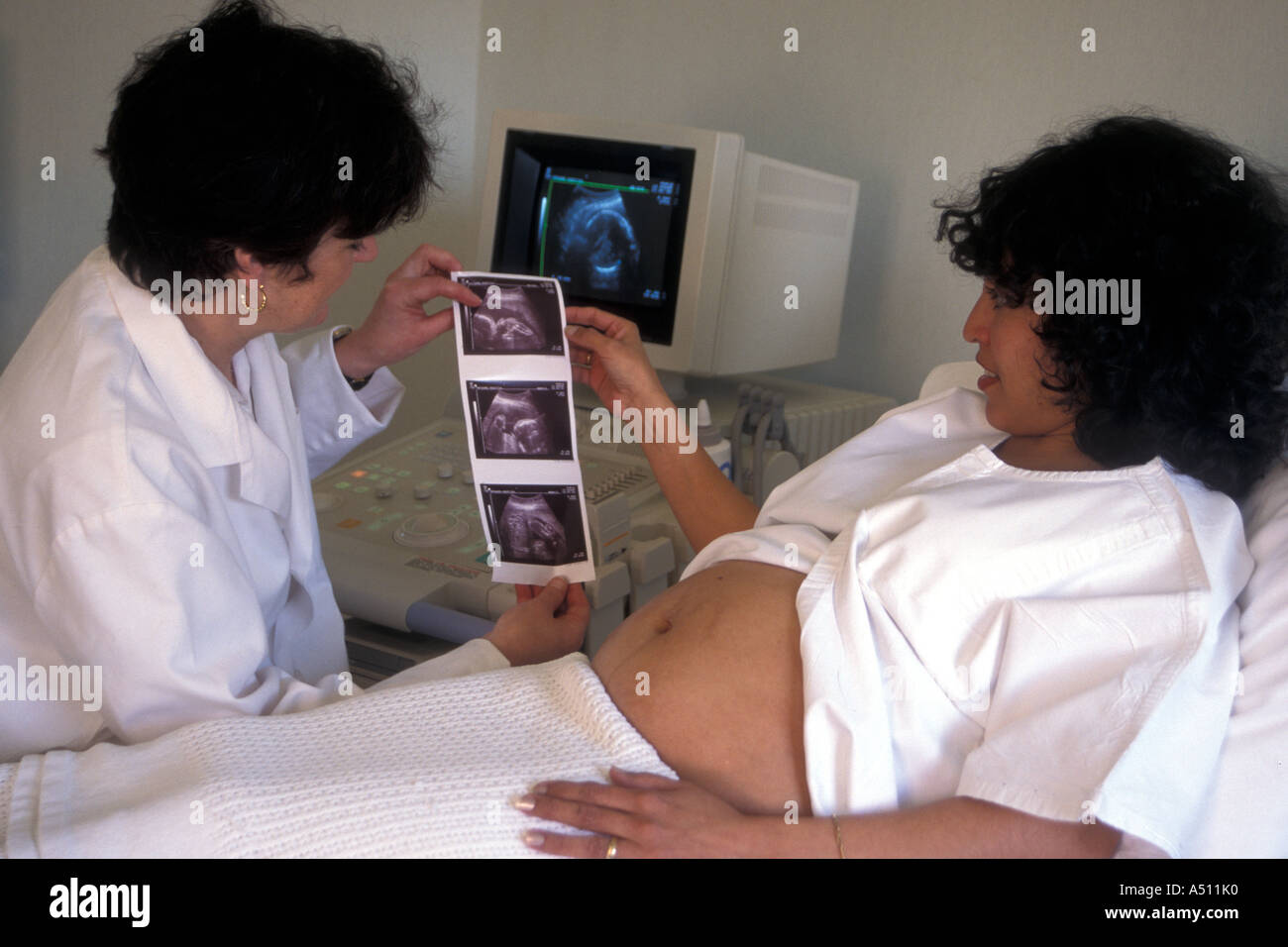 Le manipulateur radio montrant hispanic femme enceinte en clinique  pré-résultats d'échographie Photo Stock - Alamy