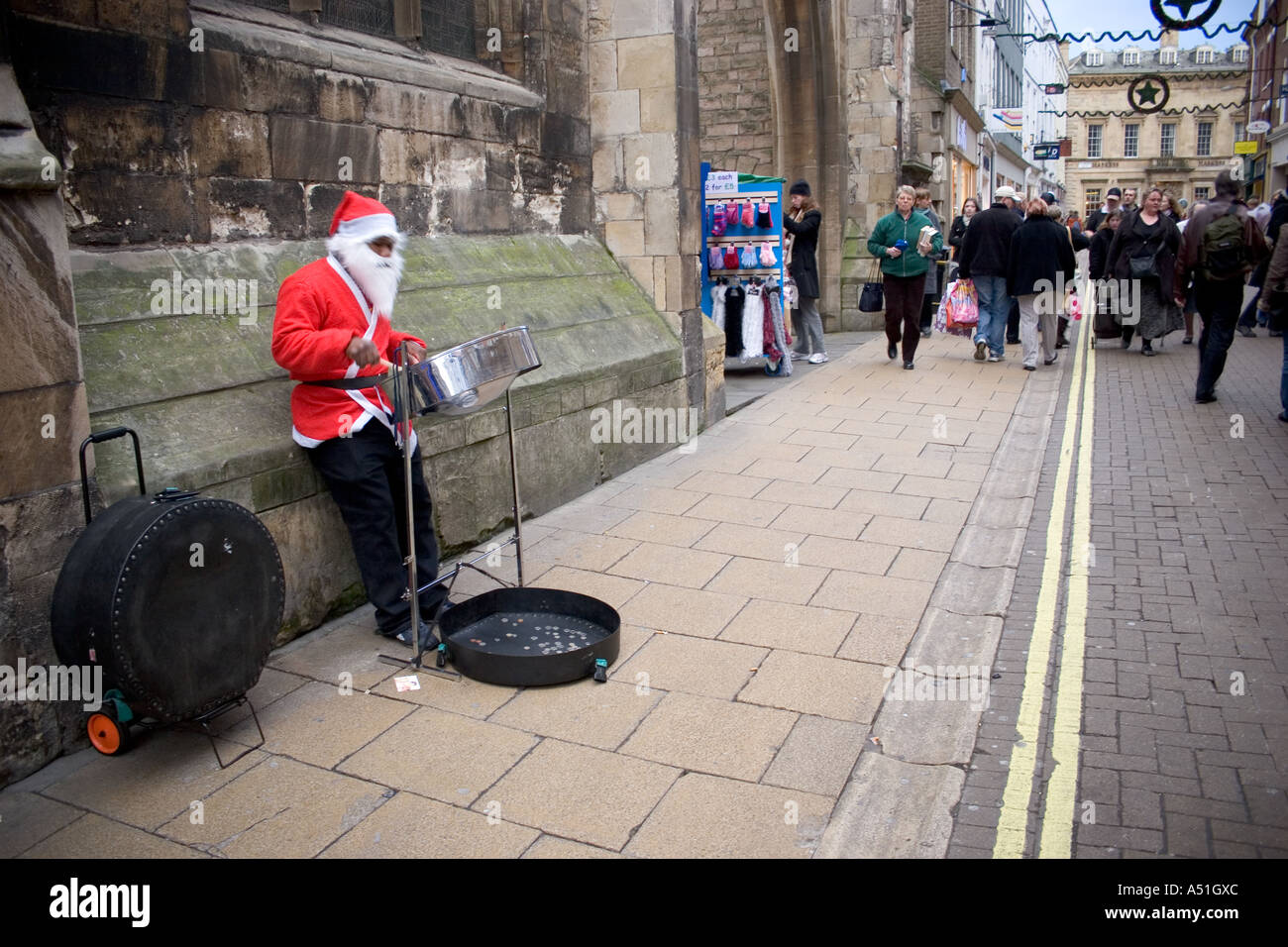 Un homme noir dans un costume père noël à jouer du tambour en acier de la rue dans les rues pour le shopping de Noël Banque D'Images