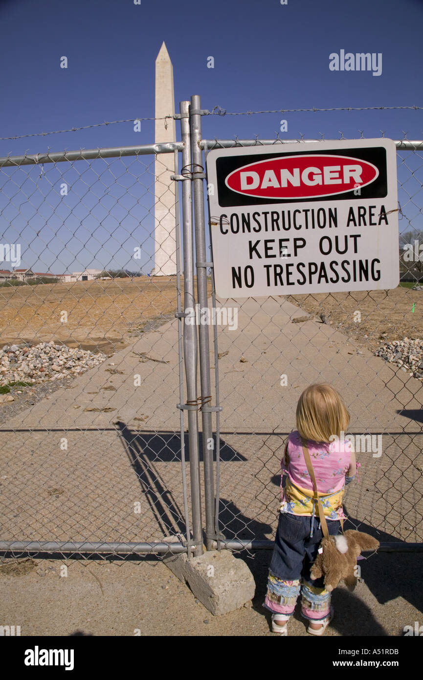 Petit enfant regarde par grillage en zone de construction autour du Monument de Washington Washington DC USA Banque D'Images