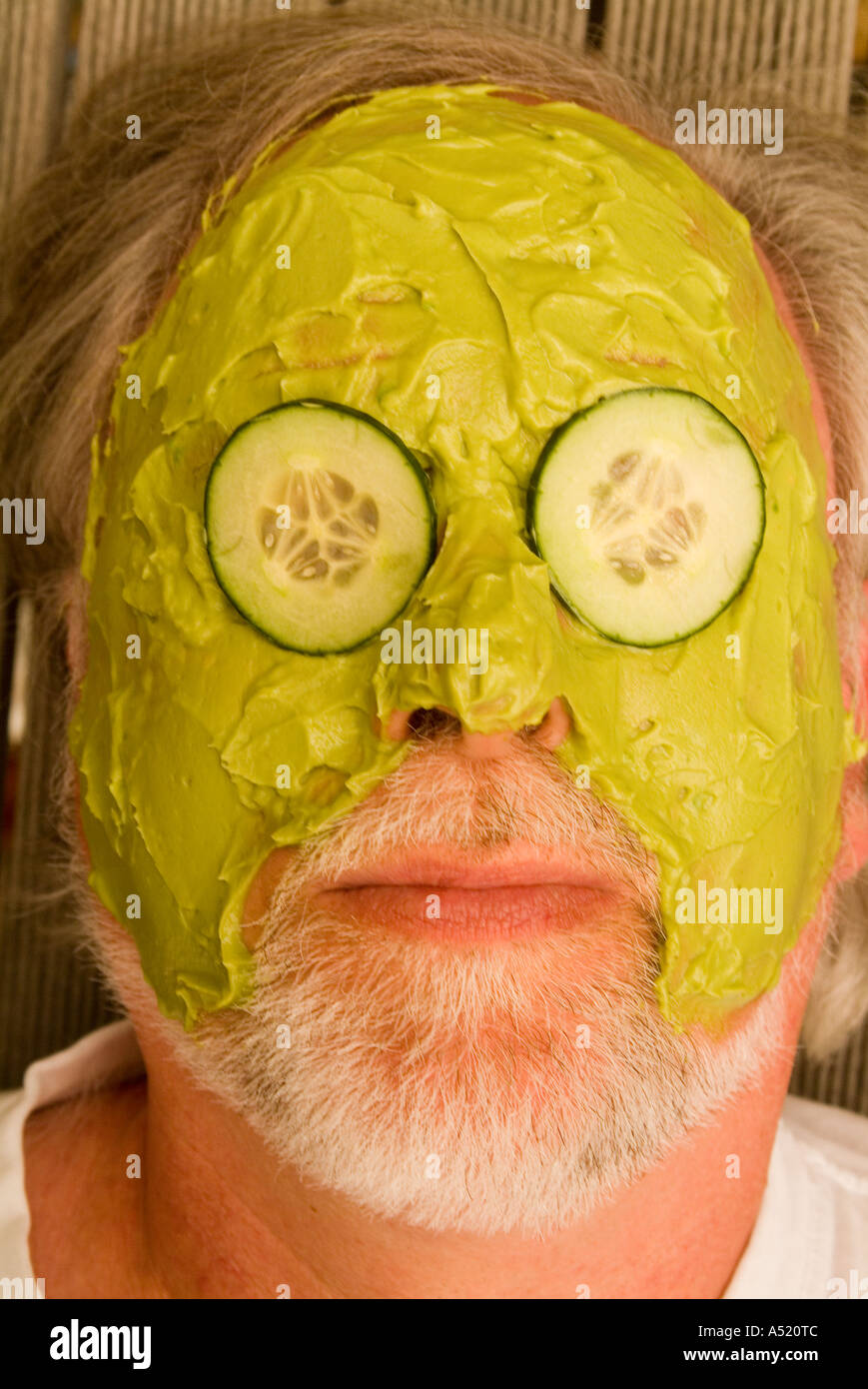 Avec de l'avocat de l'homme masque et des tranches de concombre sur les yeux  Photo Stock - Alamy