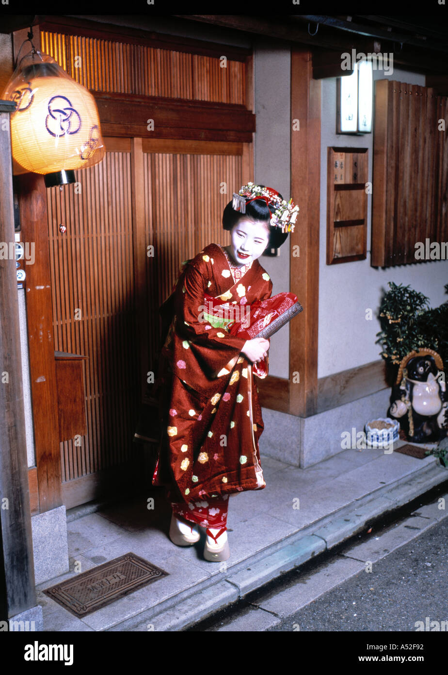 Une Maiko devant sa maison, Kyoto, Japon Banque D'Images