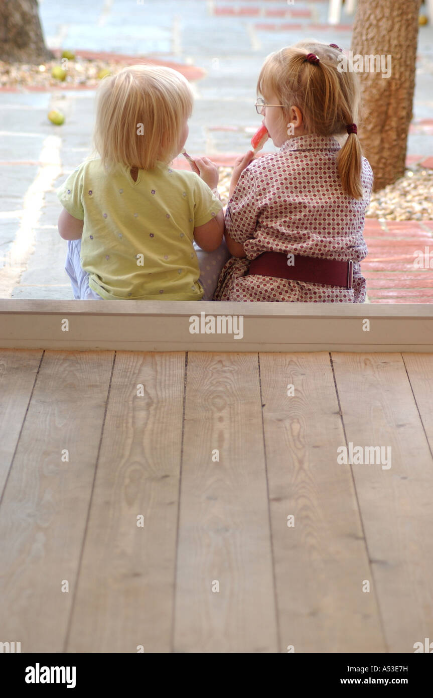 Deux amis britanniques pour parler avec des bonbons dans les jardins d'London UK Banque D'Images