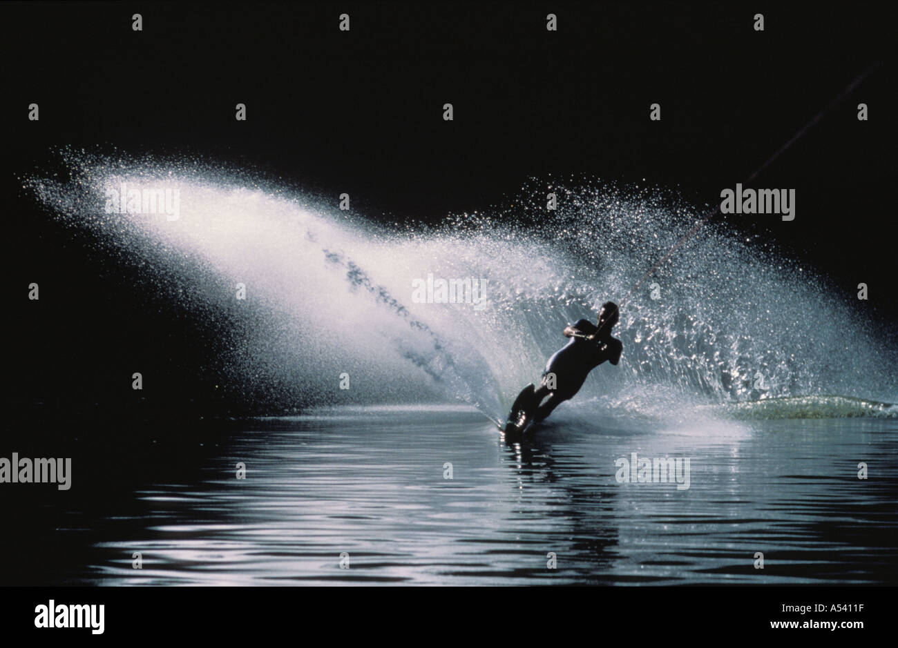 Spray blanc de ski nautique sur la rivière sombre contre Hawksberry River en Australie Banque D'Images