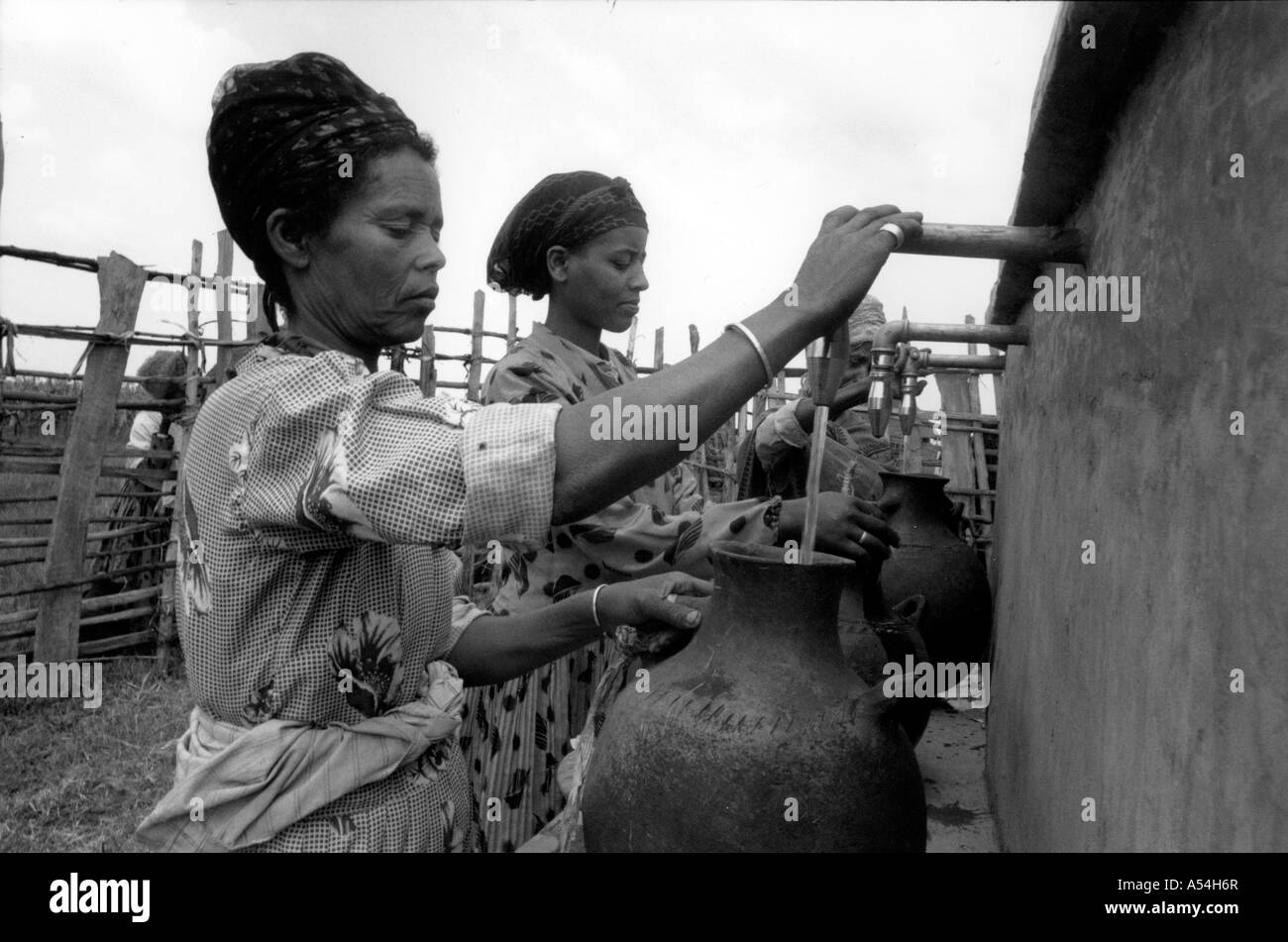 Painet ac1500 noir et blanc femmes prenant de l'eau robinet public village western shoa Éthiopie images bw pays développe Banque D'Images