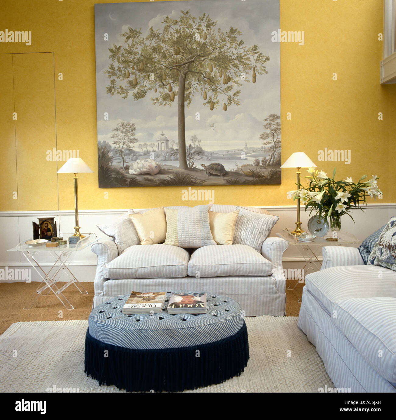 Grand style du xviiie siècle photo au-dessus du canapé gris pâle à jaune pâle salon avec grand circulaire tabouret rembourré Banque D'Images