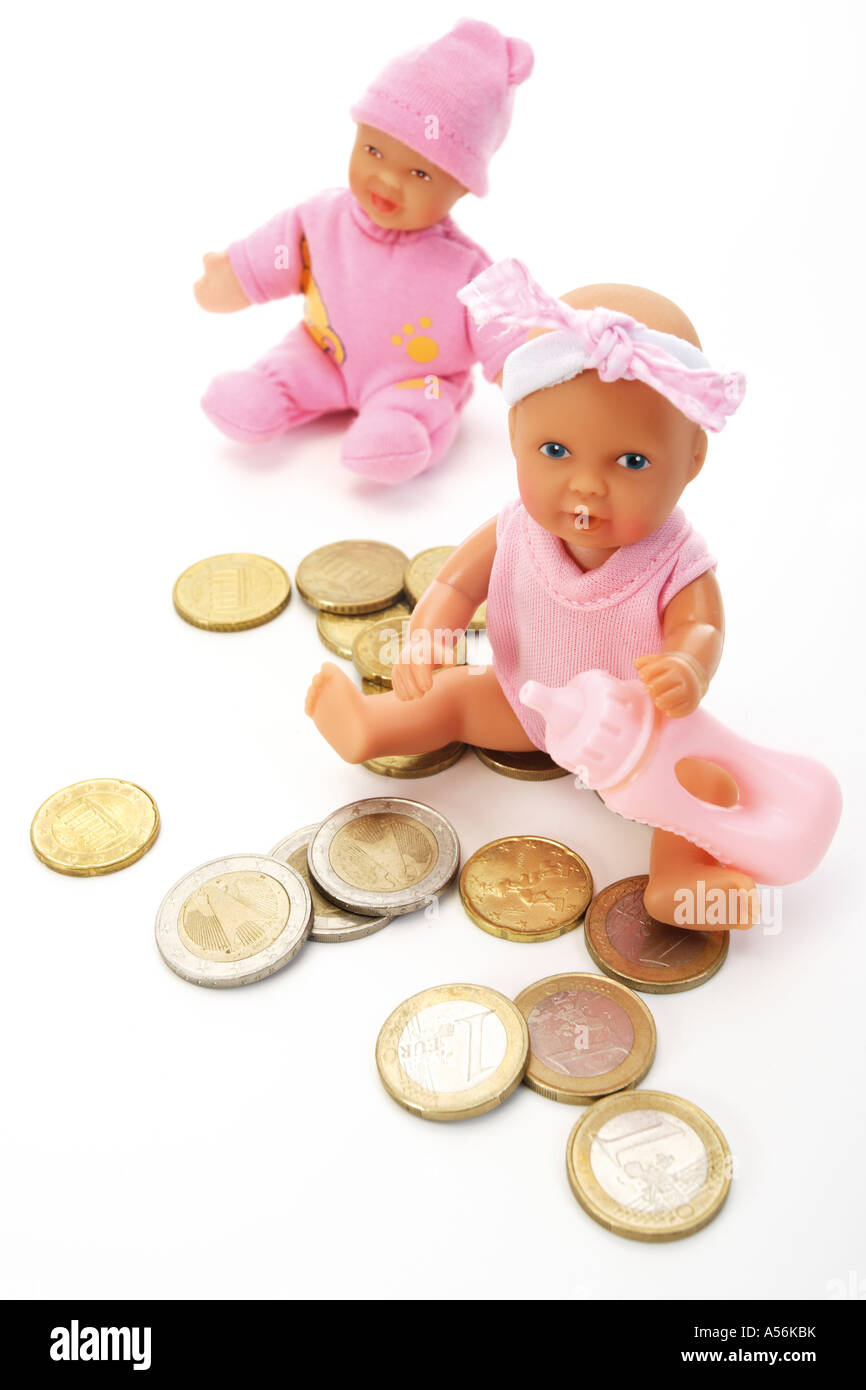Deux doll assis parmi les pièces en euros Banque D'Images