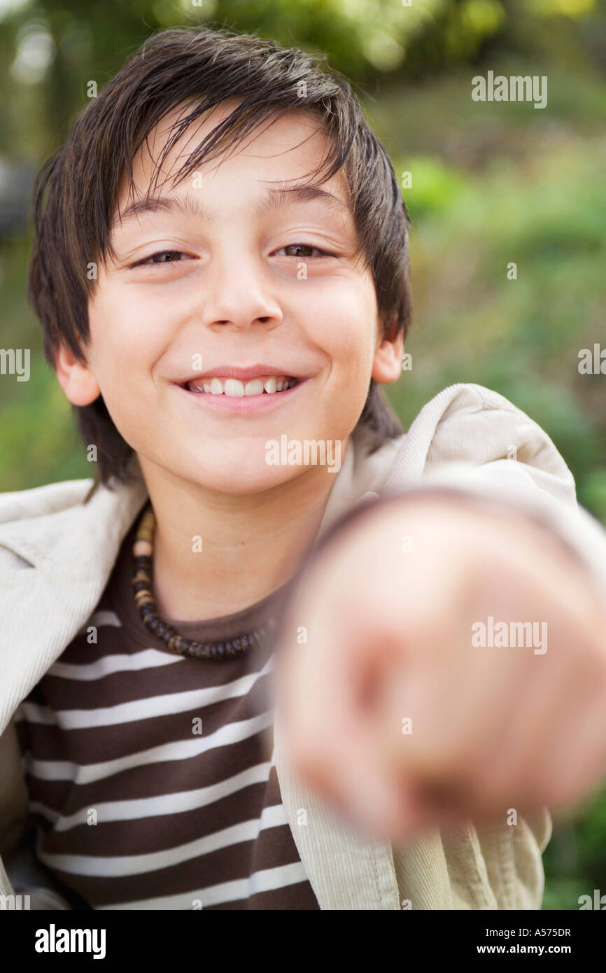 Teenage boy (13-15) qui pointe, smiling Banque D'Images