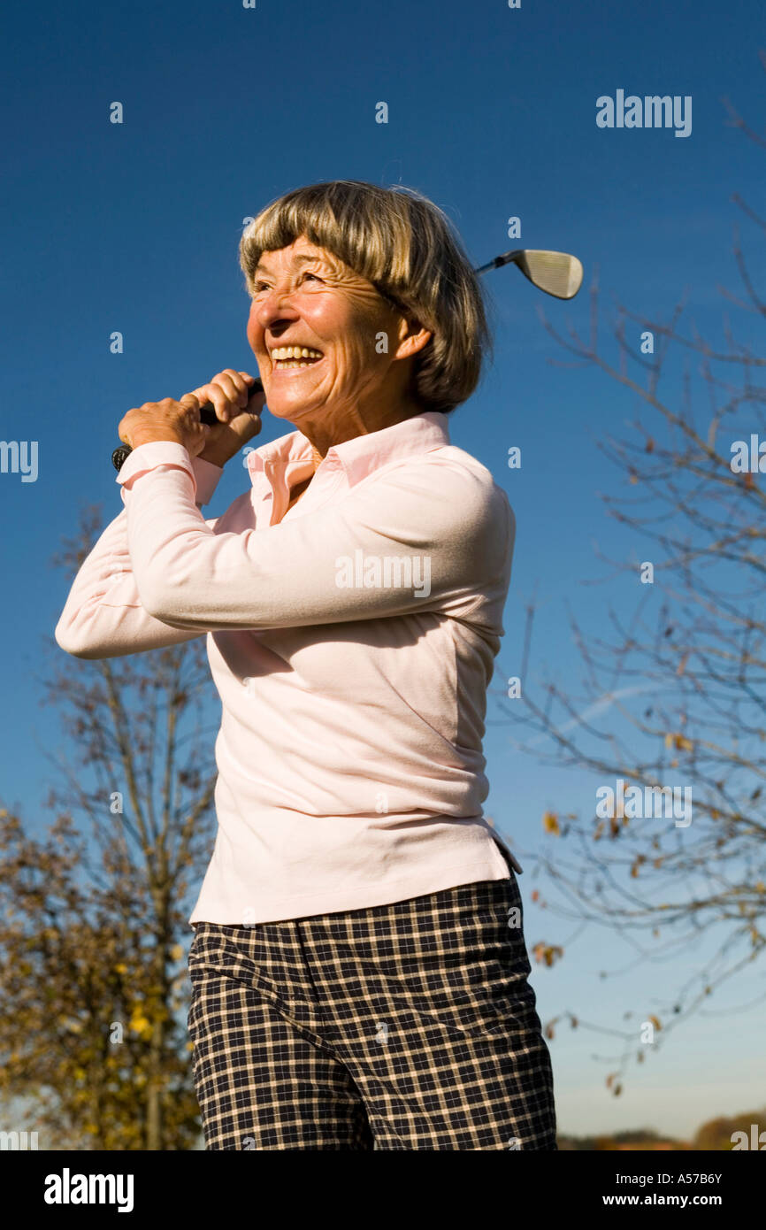 Senior adult woman holding golf club Banque D'Images