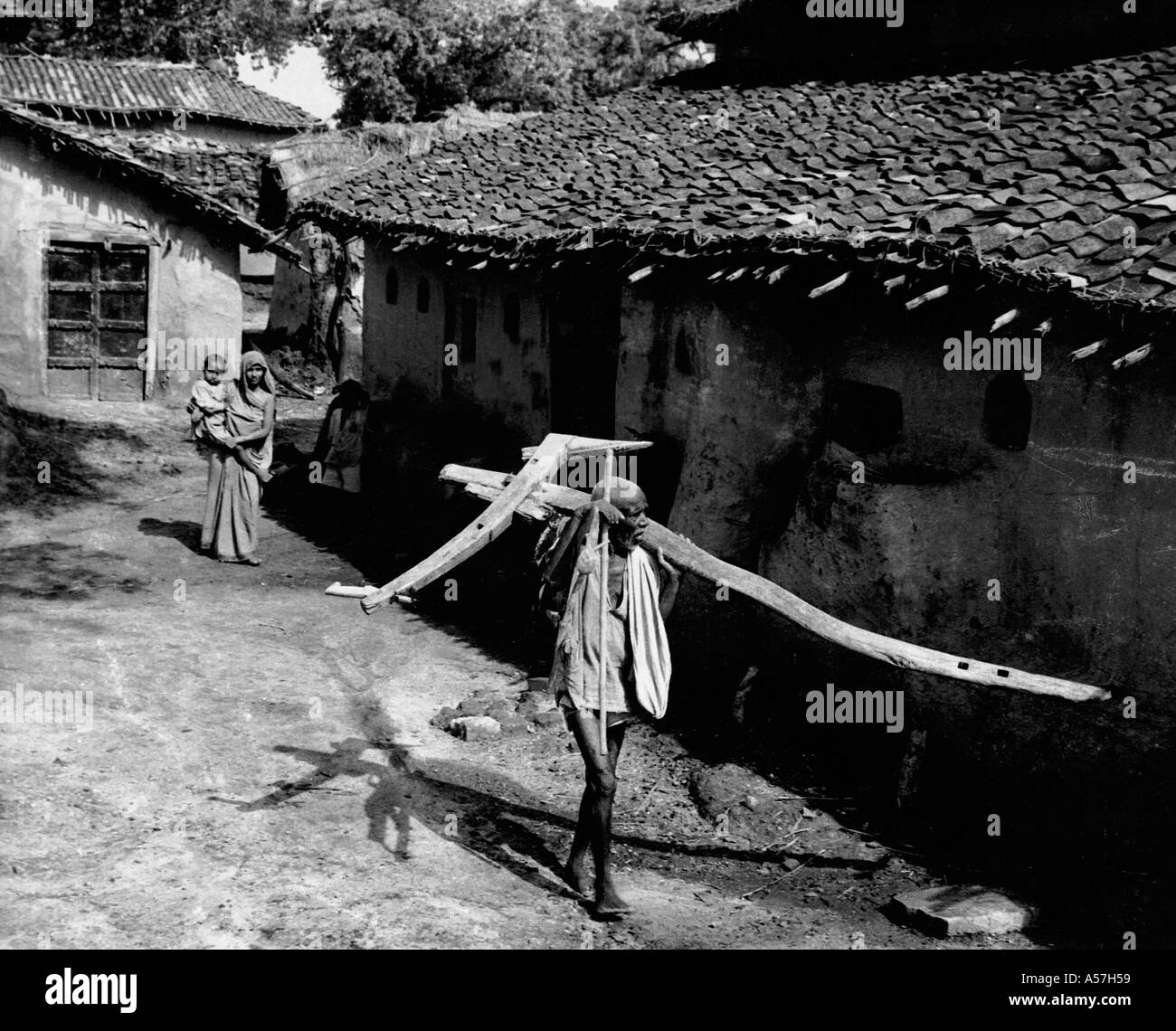 Agriculteur portant charrue village mari de rue épouse Uttar Pradesh Inde 1953 Banque D'Images