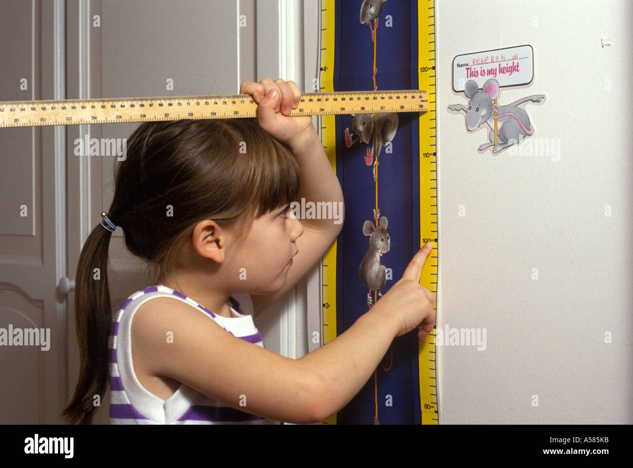 Un enfant mesurant elle-même Banque D'Images