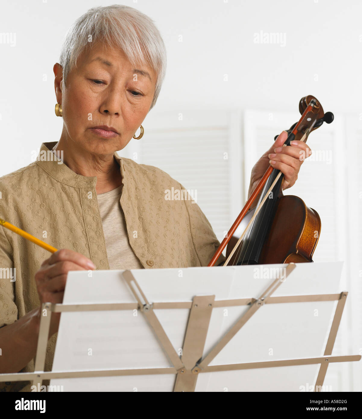 Senior Asian woman avec violon et partitions Banque D'Images