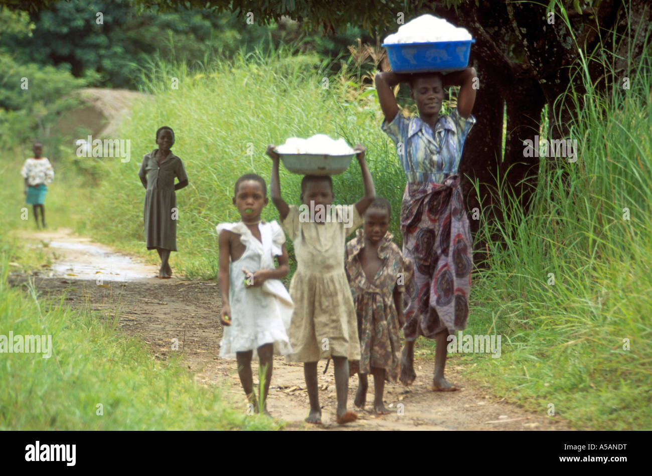 Mère et enfants transportant des seaux sur la tête, le Malawi, l'Afrique Banque D'Images
