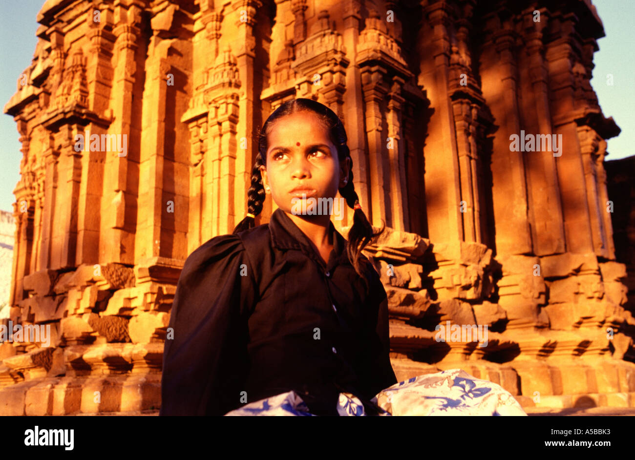 Jeune fille est assise en face d'une ruine en Chalukyan Badami situé dans le district de Bagalkot Karnataka, Inde Banque D'Images