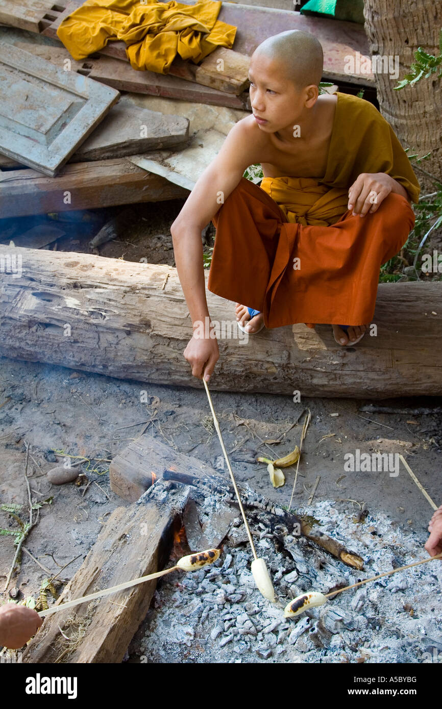 Les moines novices bananes à cuire sur le feu Wat Xieng Thong Luang Prabang au Laos Banque D'Images