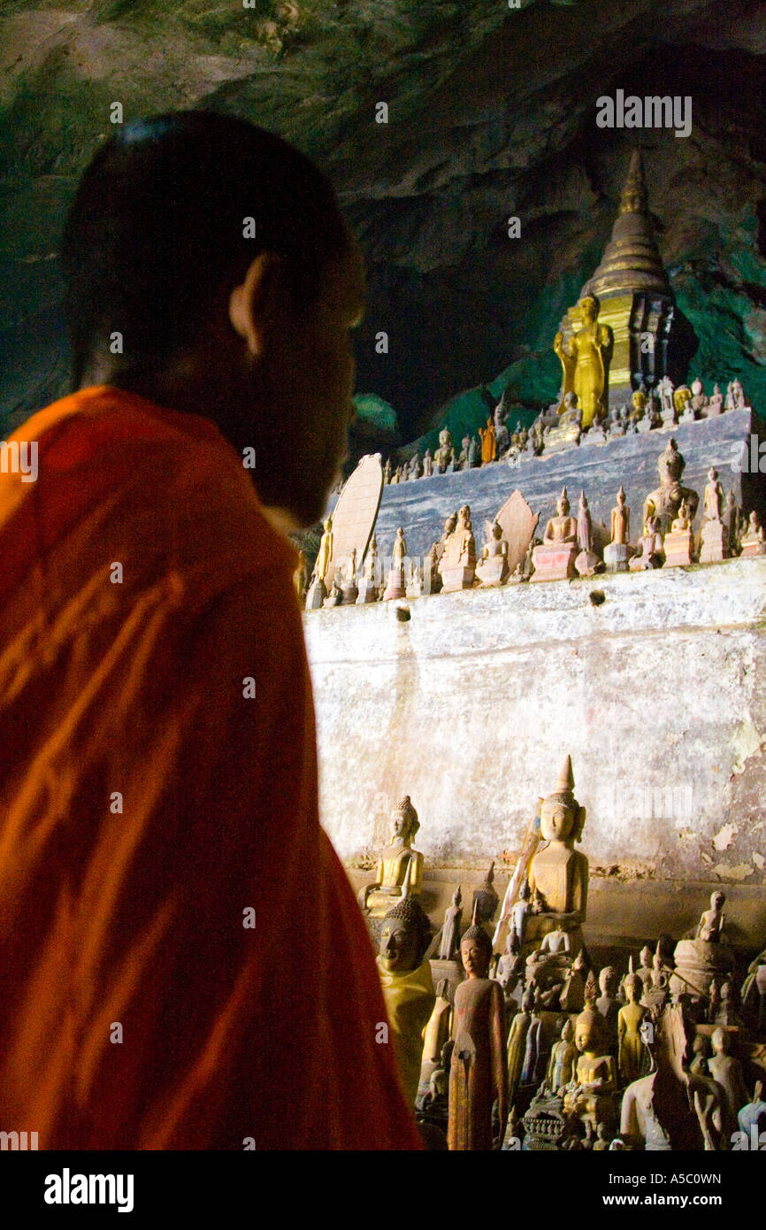 Moine à l'intérieur de statues de Bouddha à la grotte de Pak Ou Luang Prabang au Laos Banque D'Images