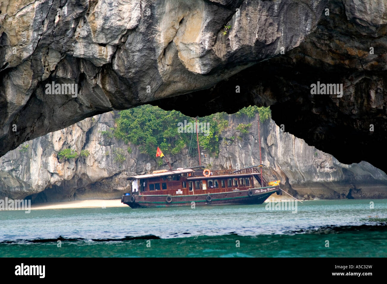 Grâce à la grotte calcaire Arch à la baie de Halong Vietnam Jonque Touristique Banque D'Images