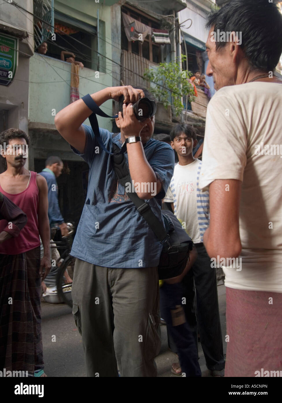 Photographe du Bangladesh au travail en photographiant man Banque D'Images