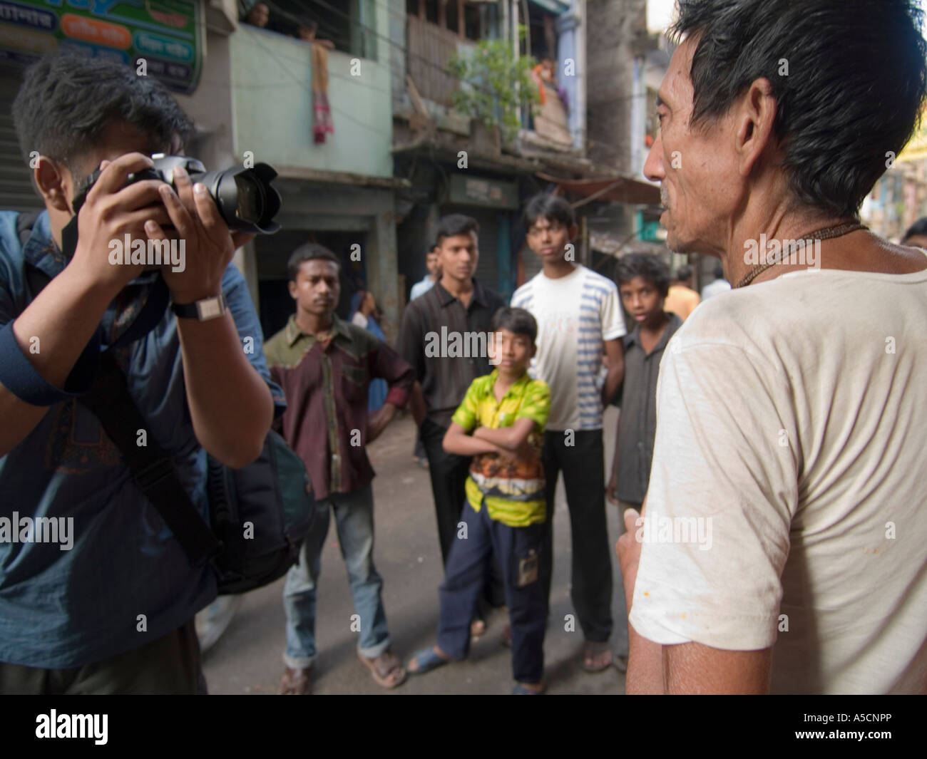 Photographe du Bangladesh au travail en photographiant man Banque D'Images