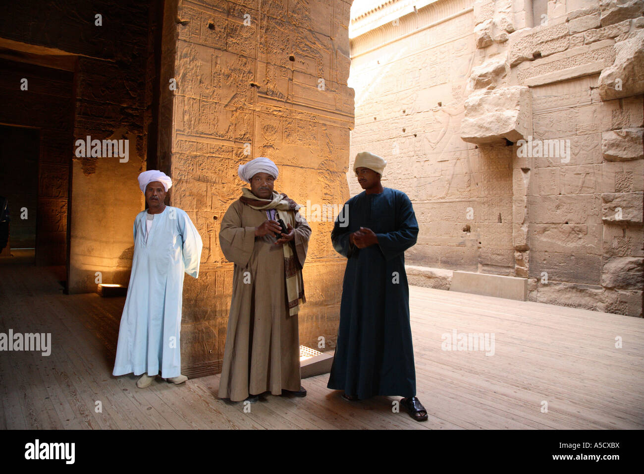 Les hommes en costume traditionnel dans le temple de Philae, Egypte Banque D'Images
