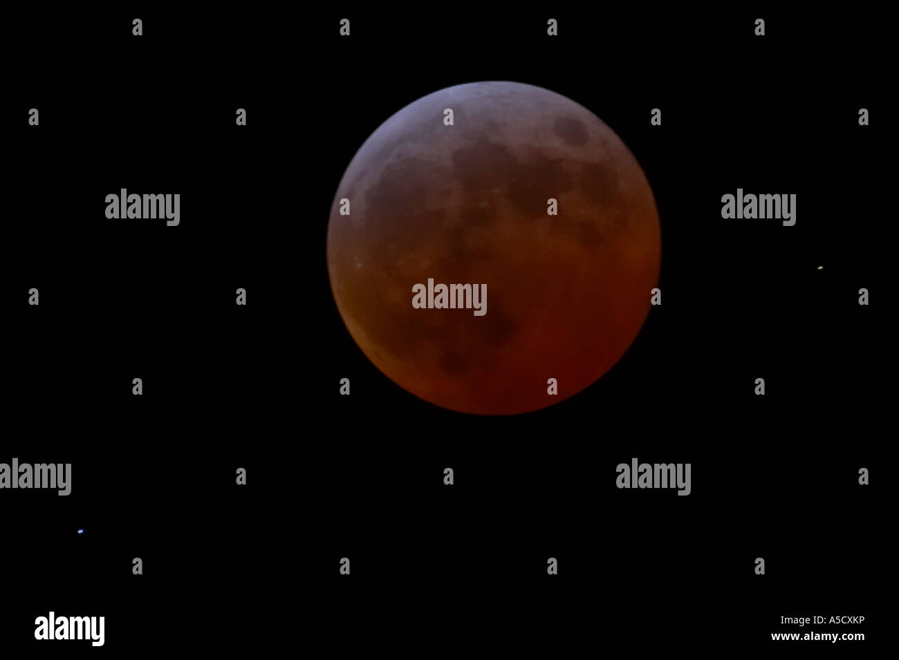 La lune devient rouge-brique durant la totalité d'une éclipse lunaire totale en cours au vu de l'Irlande du Nord en mars 2007 Banque D'Images