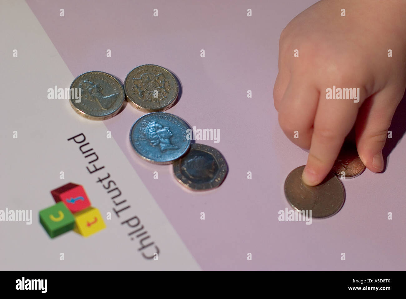 Child trust fund notice avec bébé mains ramasser de l'argent Banque D'Images