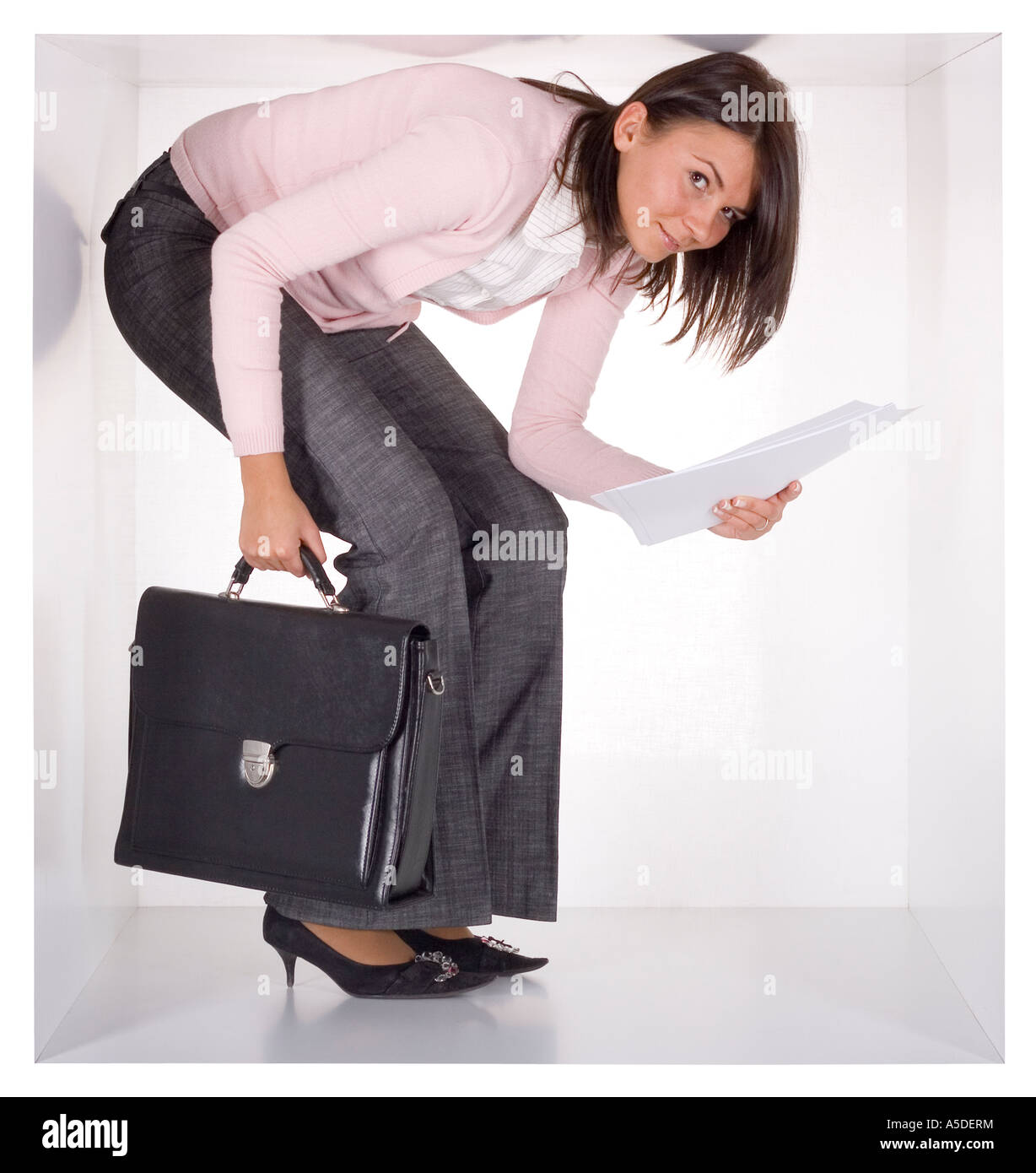 Businesswoman avec porte-documents et papiers dans le white cube étroit Banque D'Images