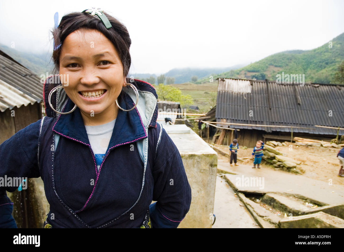 Un tribeswoman Hmong noirs sourit dans les collines de Sapa Vietnam Banque D'Images