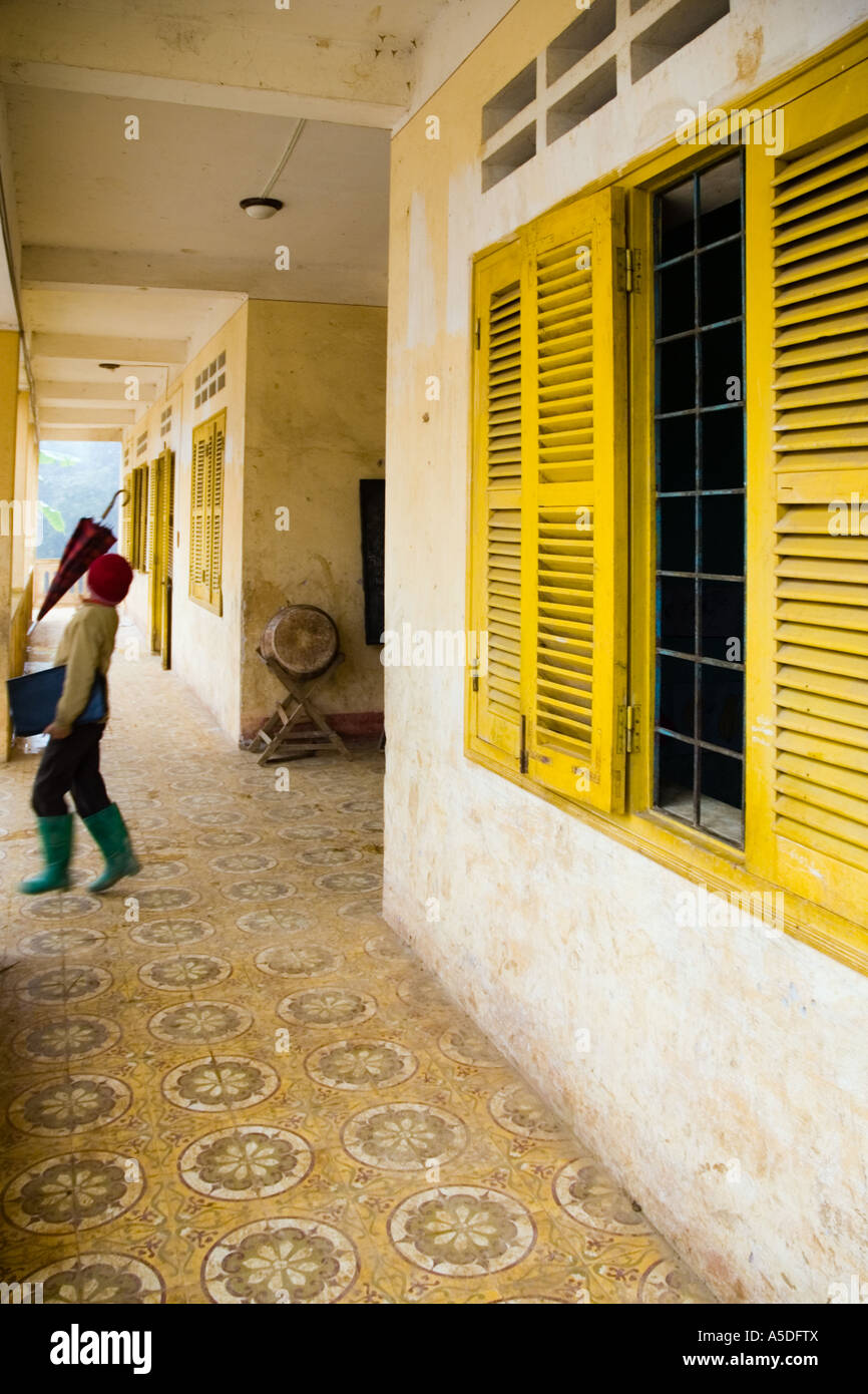 Un garçon vietnamien joue avec un parapluie dans les couloirs d'une école près de Sapa Vietnam Banque D'Images