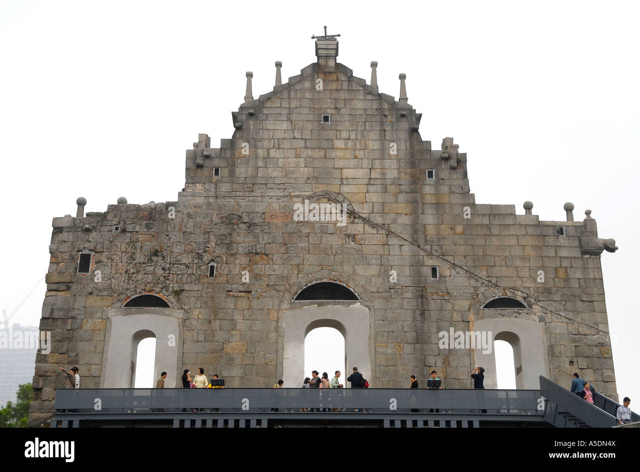 Les touristes à marcher le long de la façade arrière de la 17e siècle église portugaise de St Paul's à Santo António, Macao, Chine Banque D'Images