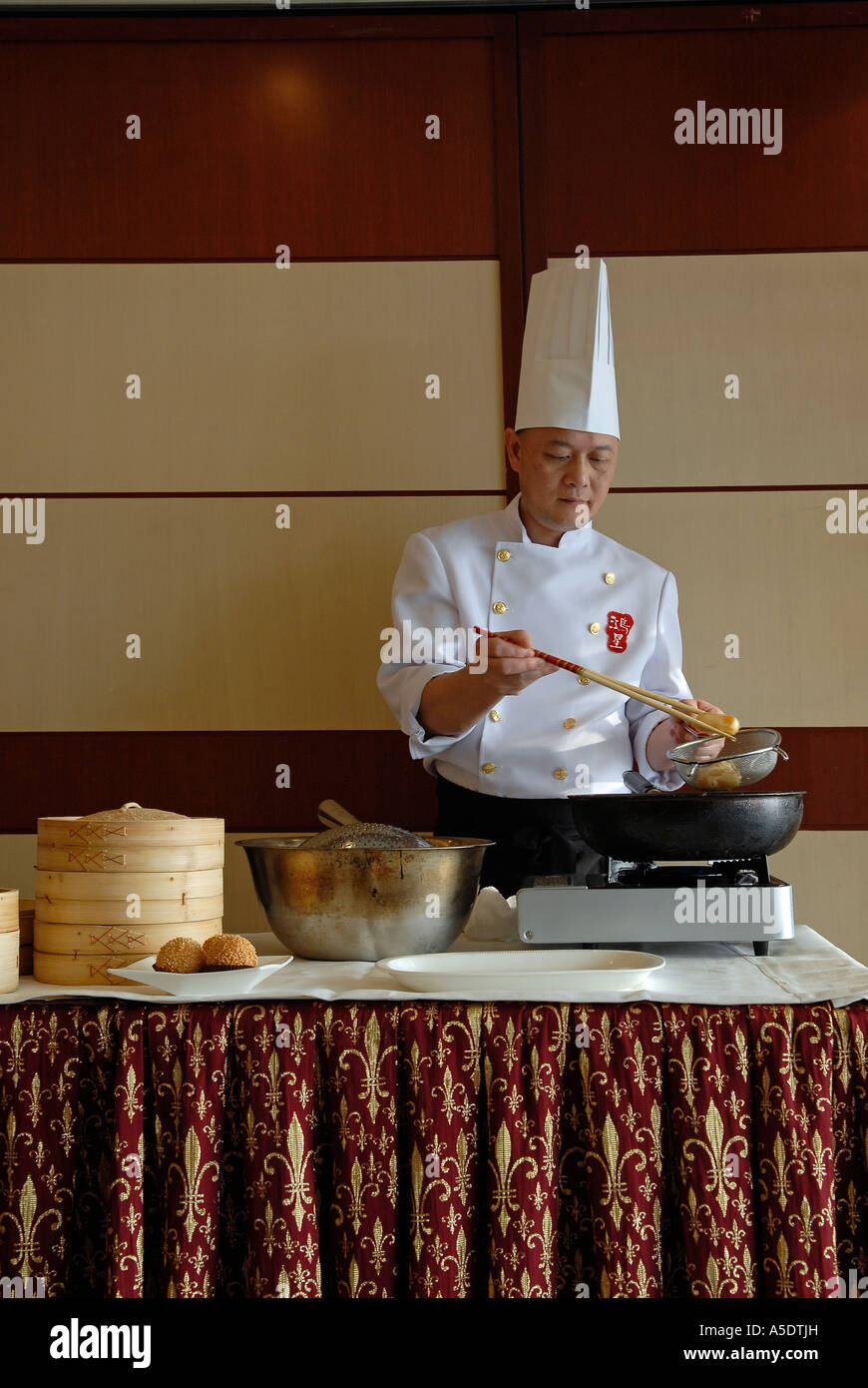 Un chef préparant des pâtisseries frites Jian DUI à base de farine de riz gluante et enrobées de graines de sésame servies dans un restaurant de Hong Kong Chine Banque D'Images
