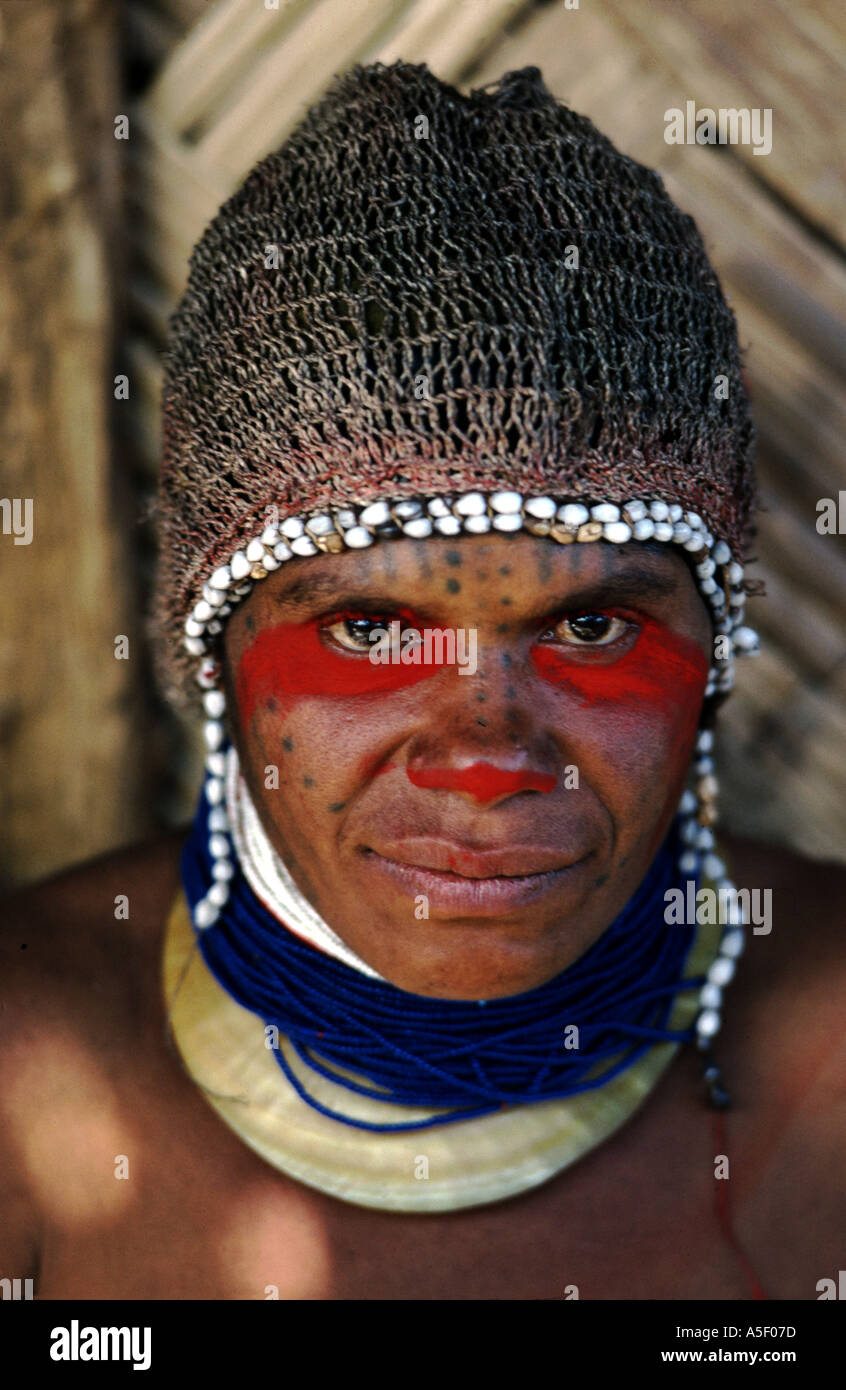Huli femme de Tari en Papouasie-Nouvelle-Guinée portant un couvre-tête décoré de coquilles de toiea et de perles bleues sur un collier de coquille de perle. Banque D'Images
