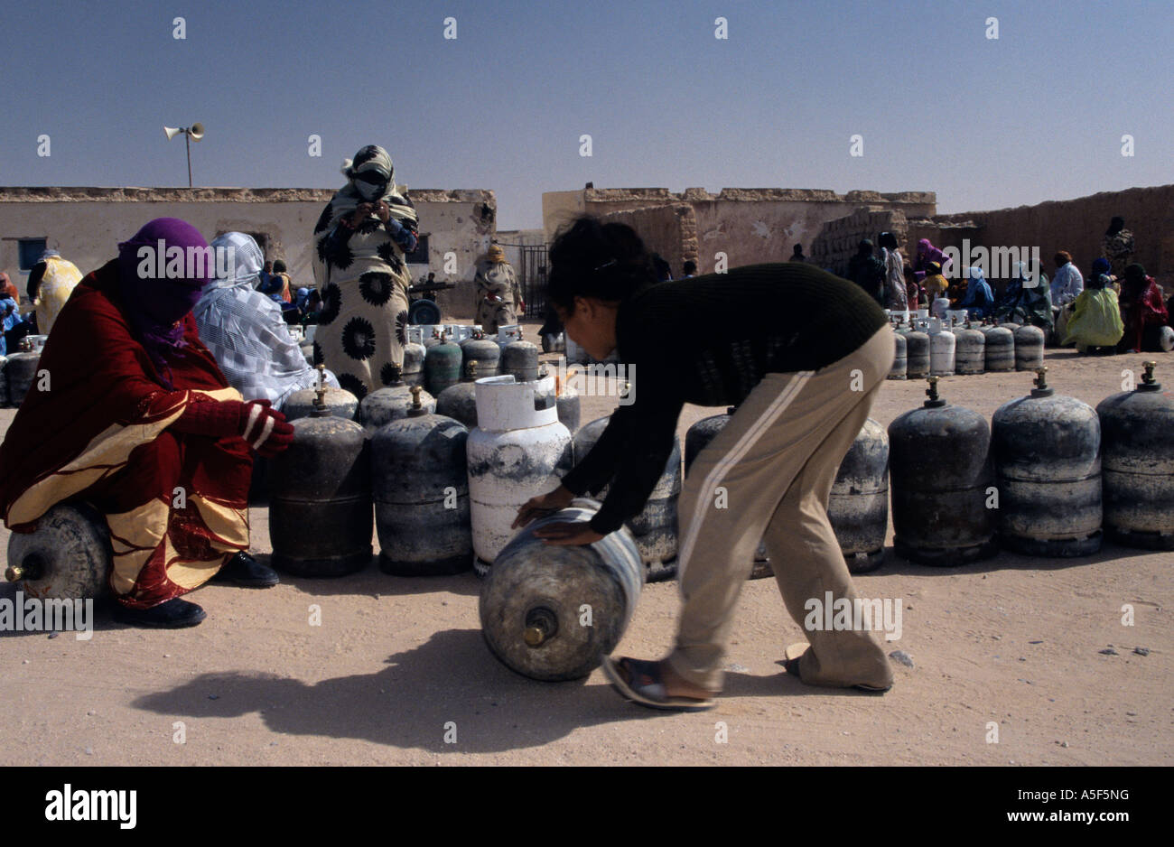 Garçon sahraoui aidant à déplacer la bouteille de gaz, Tindouf, dans l'ouest de l'Algérie Banque D'Images