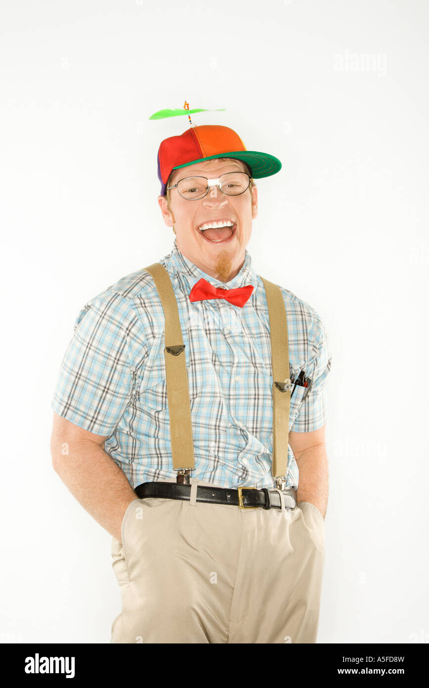 Portrait jeune homme habillé comme nerd portant chapeau hélice avec les  mains dans les poches en regardant avec un grand sourire Photo Stock - Alamy