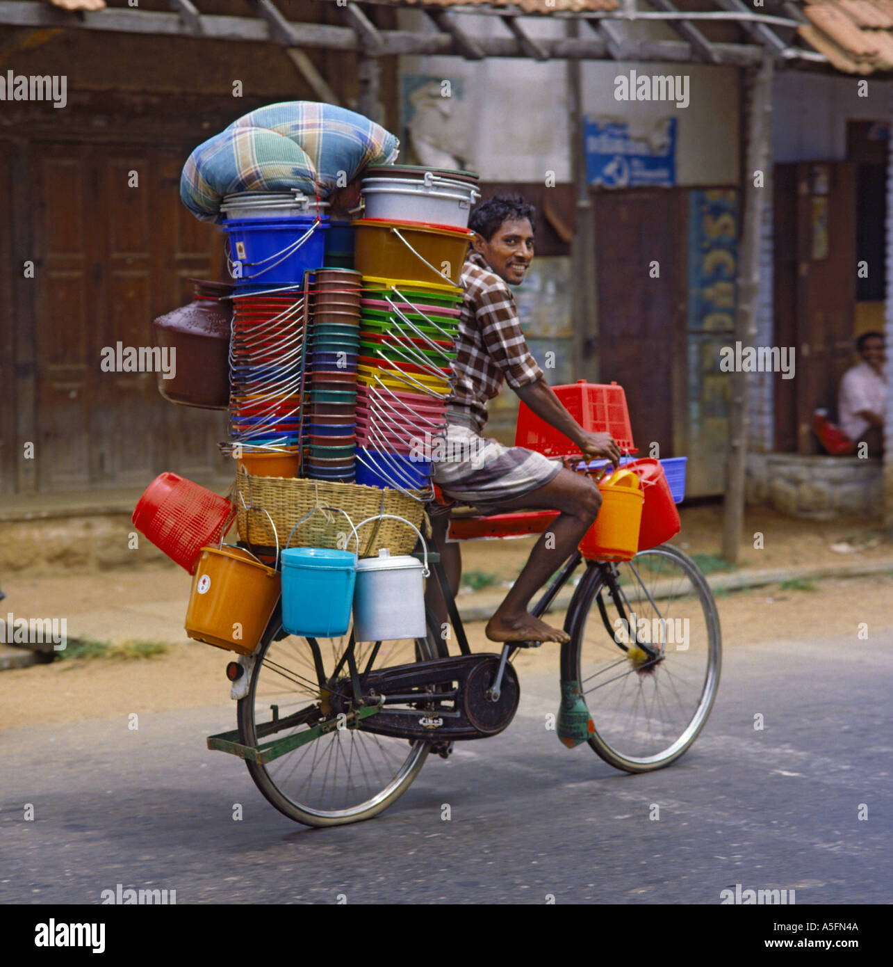 Vélo homme typique de vieux vélo haute empilée avec des seaux en plastique  coloré soigneusement équilibré pour vendre l'État du Kerala en Inde Photo  Stock - Alamy